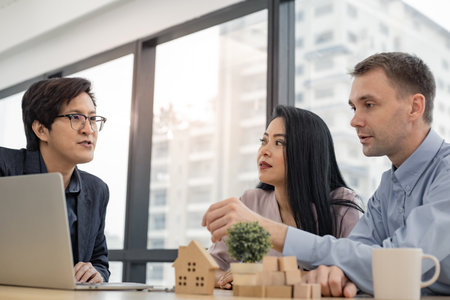 Buy or sell home concept,  sales representative offer house purchase contract to buy a house to husband and wife. House sales agents currently offering house projects to customers.の写真素材