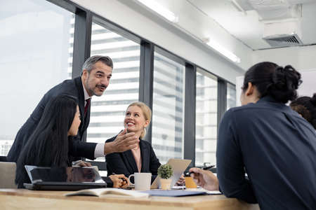 Businessman explaining new business ideas to peers. Business people discussing together in conference room during meeting at office. Meeting business concept.の写真素材