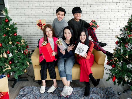 Happy of group young Asian with gifts at home in celebrating Christmas festival. Group of friends...