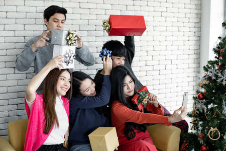 Selfie of group young Asian with gifts at home in celebrating Christmas festival. Thai teenagers...