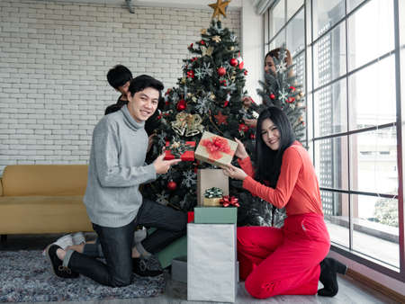 Happy party of group young Asian with gifts at home in celebrating Christmas festival. Thai teenagers celebrate Christmas and New Year. Merry Christmas and happy holidays.の写真素材
