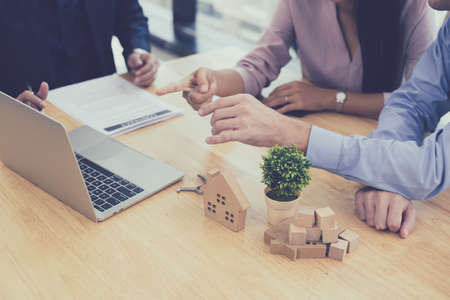Buy or sell home concept,  sales representative offer house purchase contract to buy a house to husband and wife. House sales agents currently offering house projects to customers.の写真素材