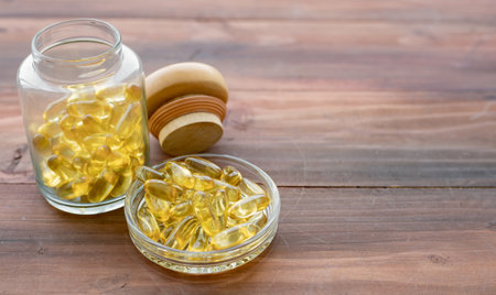 Medicine concept on wood background with copy space. Gold fish oil capsules. Concept of medicine in medical.の写真素材