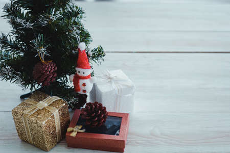 Top view of Christmas composition with tree, gift boxes, snow doll on wooden background and copy space. Accessories of Christmas and new year concept.の写真素材