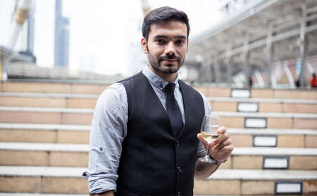 Businessman drink wine to celebrate the successful work. Caucasian man celebrate by drinking wine.