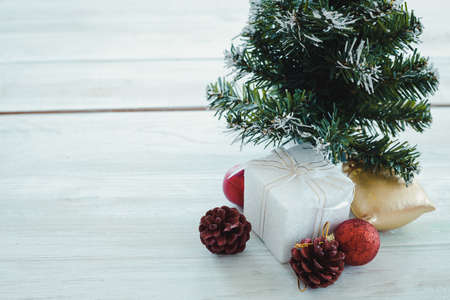 Top view of Christmas composition with tree, white gift box, red ball on wooden background and copy space. Accessories of Christmas and new year concept.の写真素材