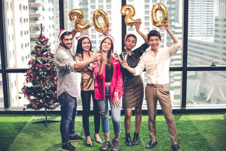 Party celebrating Christmas and New Year of group office workers with clink glasses and drink wine...