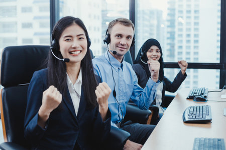 Successful of group of diverse telemarketing customer service staff team in call center. Call center worker accompanied by team. Smiling of customer support operator at work.の写真素材