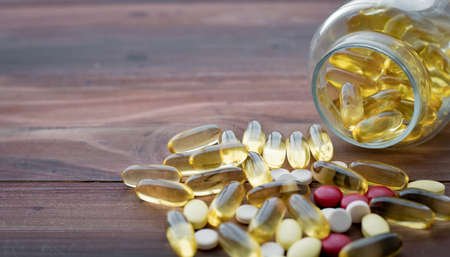 Medicine concept on wood background. Concept of medicine in medical. Pills, dietary supplements that are stacked together.の写真素材