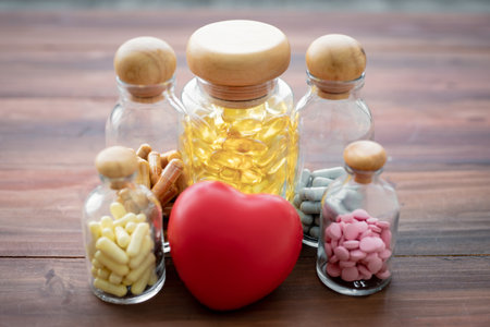 Medicine in glass bottle and heart on wood background with copy space. Concept of medicine in medical.の写真素材