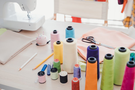 Within the workplace of a professional fashion designer. On the designer's desk, there are many...