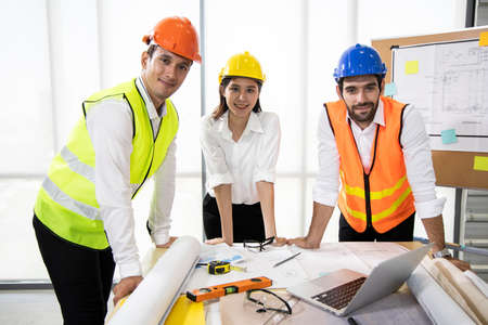 Group engineers discussion and planning about the project to be made on table. Brainstorming of engineers. Construction engineering conceptual. Three architects in office and discussing design projectの写真素材