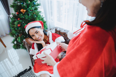 Sexy Asian woman is happy to receive a gift box from friend on Christmas day.の写真素材