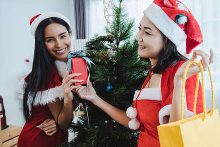 Sexy Asian woman is happy to receive a gift box from friend on Christmas day.の写真素材