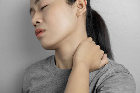 Woman with pain in neck. Concept woman suffering from pain in neck.の写真素材
