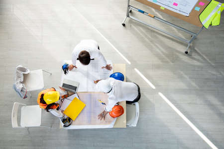 Top view group engineers discussion and planning about project to be made on table. Brainstorming of...