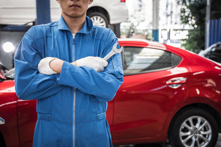 Arms crossed of car mechanic with wrench in garage. Repair service concept. Car repair and...