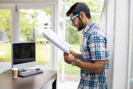 Handsome caucasian man with reading business news at home in the morning.