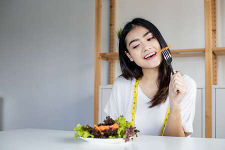 Happy woman holding dish vegetable for healthy diet with smile in healthcare. Eating fresh organic...