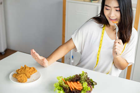 Woman choose to eat healthy vegetables and refuse to eat fried chicken in good healthy concept.の写真素材
