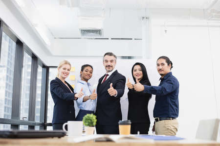Successful business concept, group of business people thumbs up in conference room.