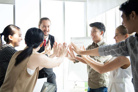 Success of group business people with join hands of teamwork in meeting room. Hands coming together...