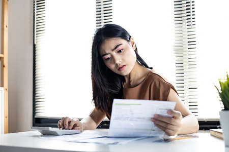 Young woman calculates debt with stress from many bill credit.の写真素材