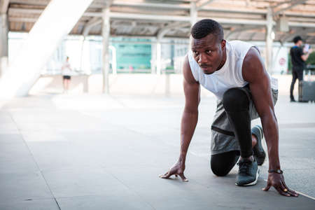 Athlete man in running start pose on the city street.の写真素材