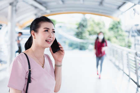Senior woman in conversation using mobile phone while laughing with someone.の写真素材