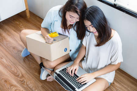 Asian women shopping online using a credit card to pay for the product. Convenience shopping order online Pay via credit card Waiting to receive parcels at home.の写真素材