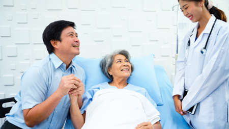 Female doctor said the results of the treatment improved and recommend caution to elderly patients and her son. Female patient and her son were smiling brightly.の写真素材