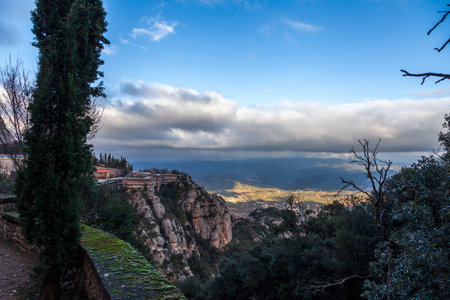 Breathtaking view of the Montserrat mountain range on a sunny spring day near Barcelona, Catalonia, Spain. Colorful mountain landscape. The shadow of the clouds falls to the ground.の写真素材