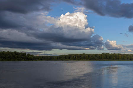 Cloudy sky over the river in the evening. Picturesque landscape with clouds and a river.の写真素材