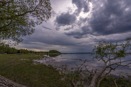 Mystical landscape at dawn. Early morning. Fog on the river. Beautiful dawn in the summer by the river. A man floats in a boat against the background of dawn.の写真素材