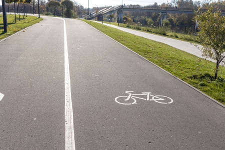 White road markings for pedestrians and cyclistsThe walking and cycling paths in the park are separated from each other. Infrastructure for walking and physical activity in the parkの写真素材
