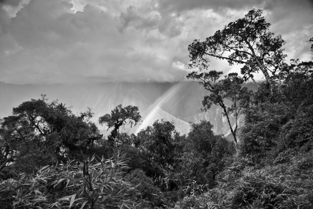 In a cloudy day, a rainbows appears between the mountains of the jungle near Machu Picchu, Cusco, Peru の写真素材