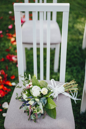Wedding bridal bouquet with roses on the chairの写真素材