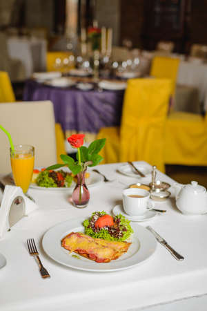 Breakfast for two in empty restaurant. Toast with fried bacon and cheese on the table. Social distancingの写真素材