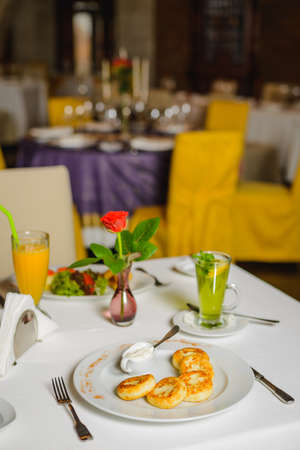 Breakfast for two in empty restaurant. Toast with fried bacon and cheese on the table. Differential focusの写真素材