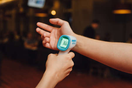 Contactless Infrared thermometer. Temperature measurement in a public placeの写真素材