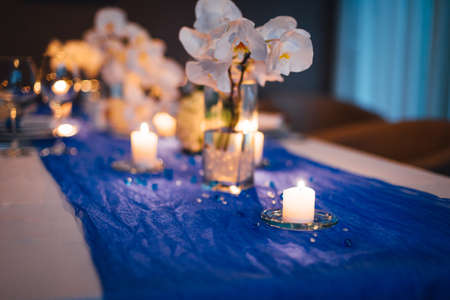 Wedding table decorations with orchids, candle lightの写真素材