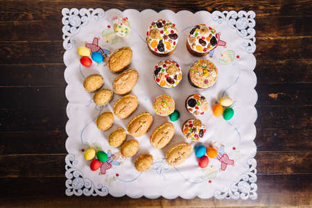 Traditional ukrainian easter Kulich cake, easter cookies of egg form in retro style, and Easter eggs on a wooden desk on embroidered handmade towelの写真素材