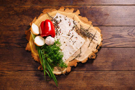 Vegetables - onion, garlic, paprika, greens, served with the lavash on a wooden plate, standing on a rustic table. food photography composing itemの写真素材