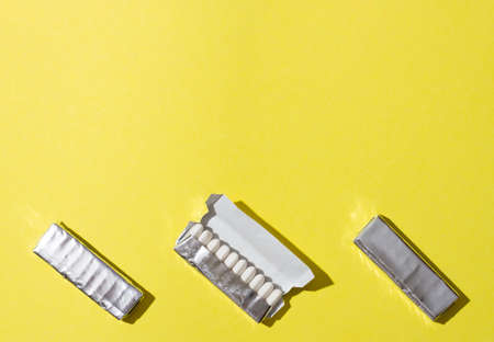 Open package of gum on yellow background.