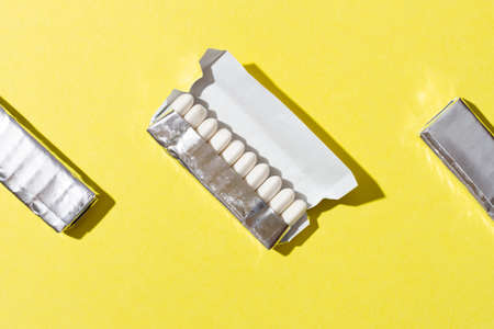 Open package of gum on yellow background.の写真素材