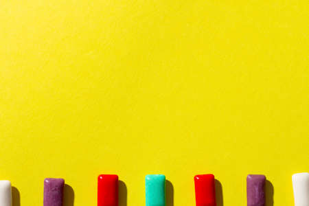 Multi-colored chewing gum on a yellow background.の写真素材