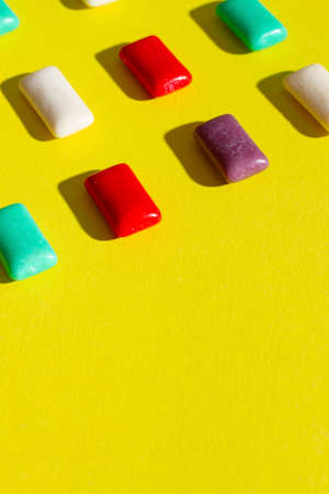 Multi-colored chewing gum on a yellow background.の写真素材