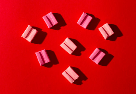 Pink gum on a red background.の写真素材