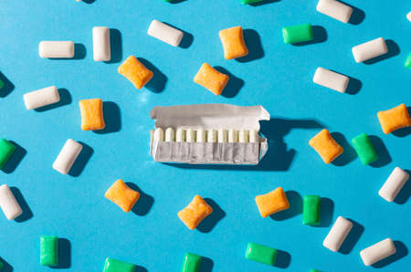 Multi-colored chewing gum on a blue background.の写真素材