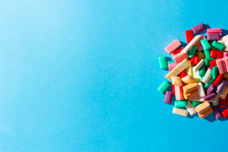 Multi-colored chewing gum on a blue background.